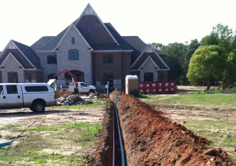 Utility trench and pipe run across a custom home site